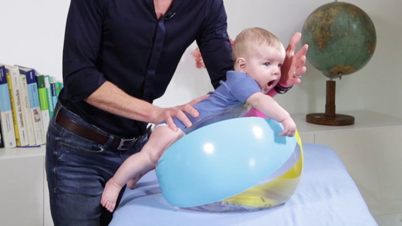 Training der Bauchlage im Säuglingsalter auf einem Wasserball