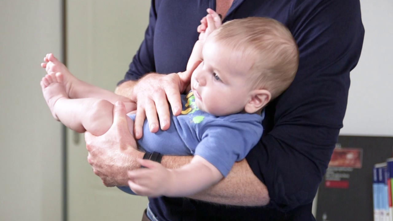 Manejo según Bobath: llevar al bebé sobre la parte interior de codo para corregir la rotación preferida de la cabeza